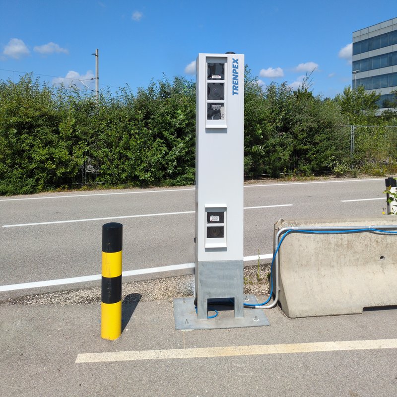 El TRENPEX-RoadGate se encuentra en la vía de acceso a una empresa industrial para registrar de forma completa el tráfico de mercancías. La caja de control, que ocupa poco espacio, incluye un sistema de cámaras con sensores de alta calidad y funciona en combinación con una sofisticada tecnología OCR.